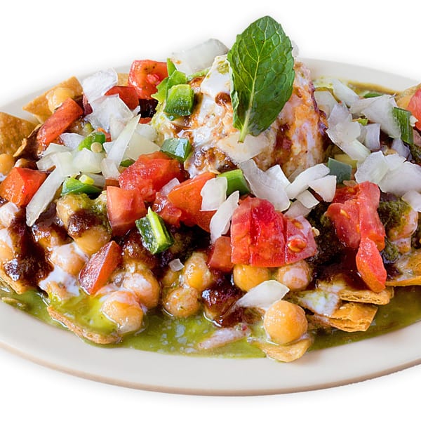 Asma's Cuisine's Pakistani chaat with chickpeas, tomatoes, onions, sauces, and a mint leaf.