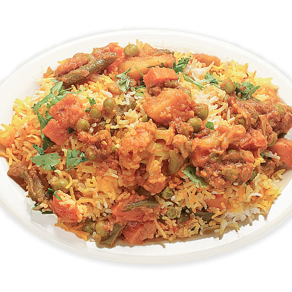 A close-up of Asma's Cuisine's vegetable biryani, featuring rice, cauliflower, peas, and green beans.