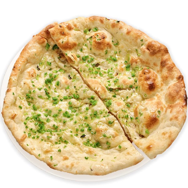 Two pieces of Pakistani garlic naan bread, topped with green herbs, on a white plate.