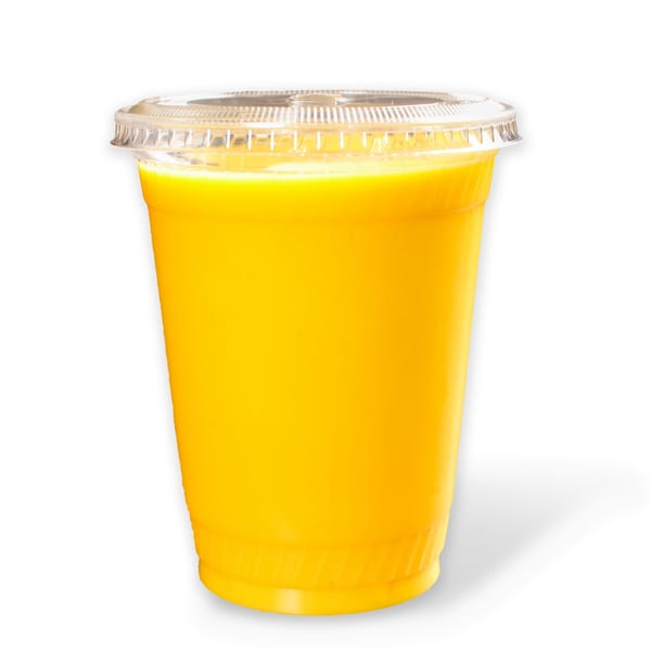 Bright yellow mango lassi in a clear plastic cup with a lid, ready to drink.